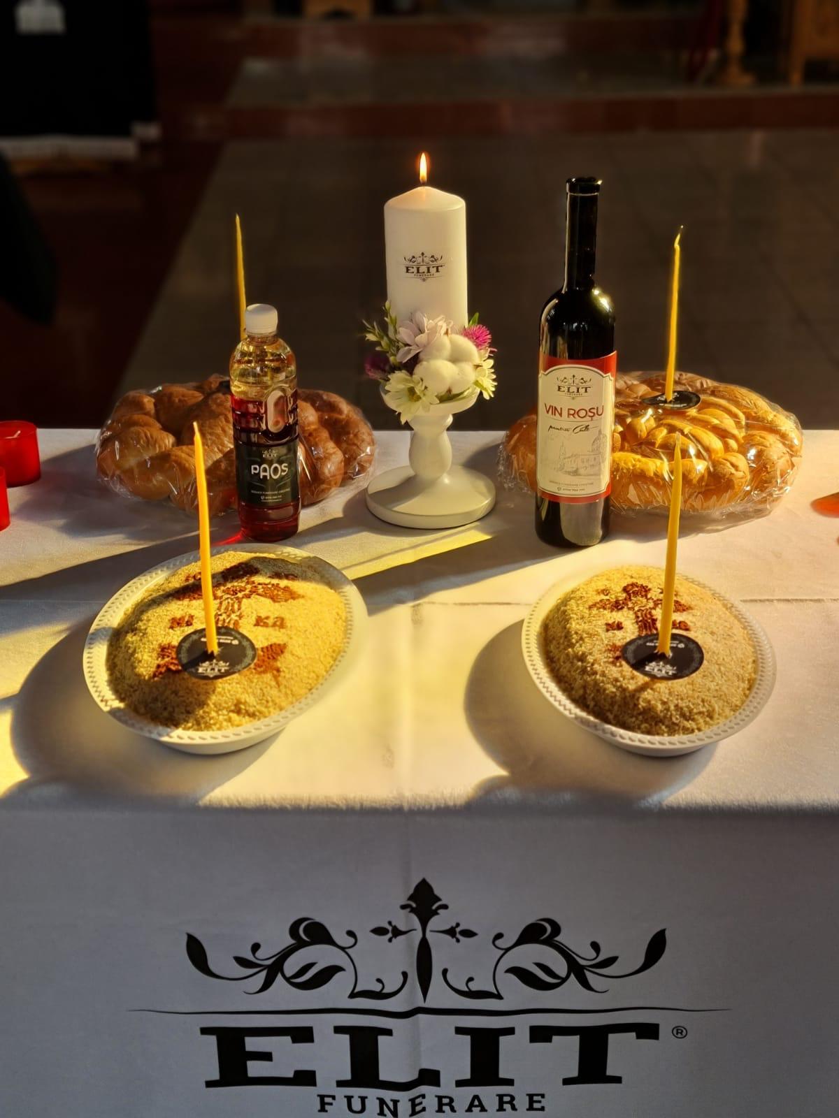 Masă de pomenire cu lumânare aprinsă, colaci și vin